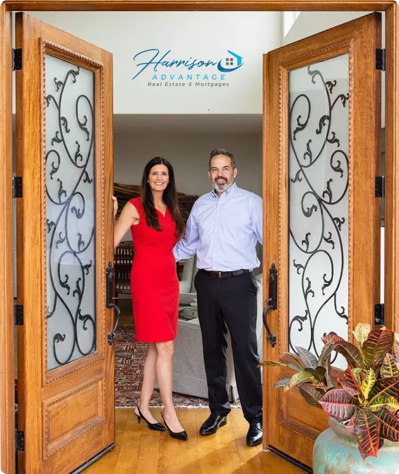 Harrison Advantage founders standing at the entrance of a home, representing their real estate and mortgage advisory services.