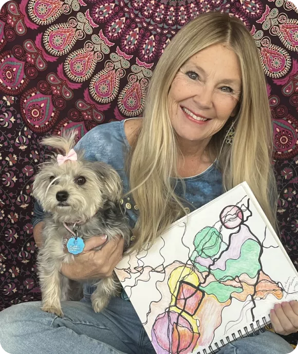 Soul Healing founder Linda Sego smiling while holding her small dog and displaying a colorful neurographic art drawing.