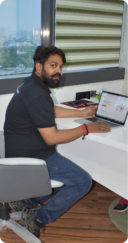 Team member working on a laptop in the CF Funnels office during a design and development session.